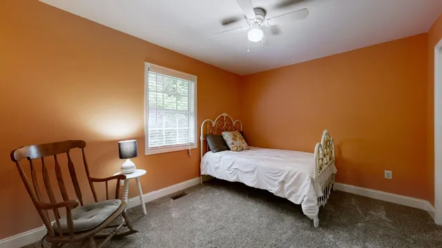 a bedroom with a bed chair and window