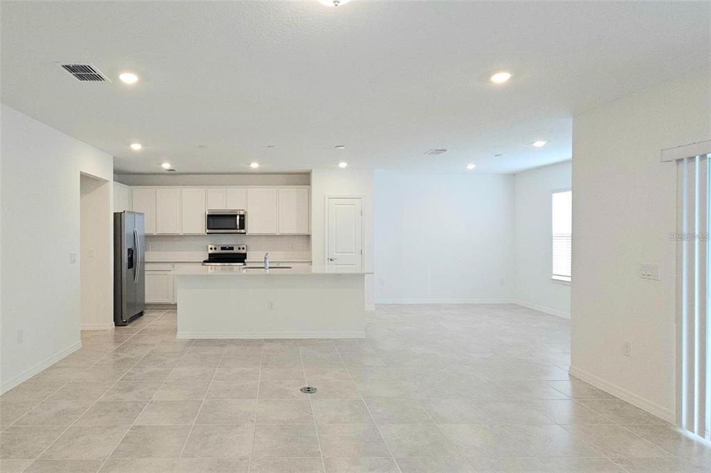 304 Woodsage Place Lake Alfred, FL 33850 - Photo 5 of 30 a view of kitchen with stainless steel appliances kitchen island a sink a refrigerator and white cabinets with wooden floor
