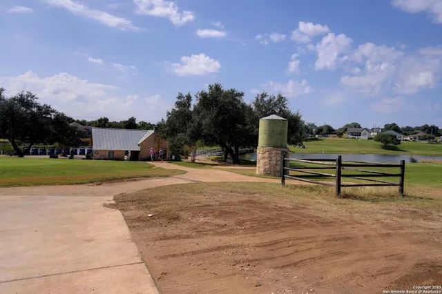 a view of a house with wooden fence next to a road