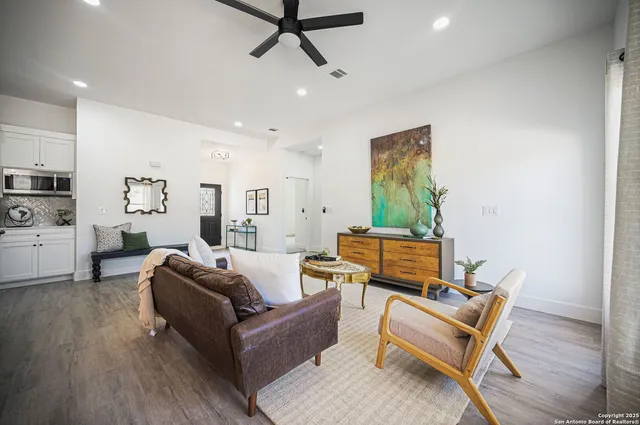 a large kitchen with stainless steel appliances kitchen island granite countertop a stove a sink a refrigerator and a wooden floors