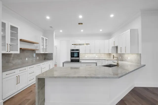 a large kitchen with stainless steel appliances granite countertop a sink a stove and a granite counter tops