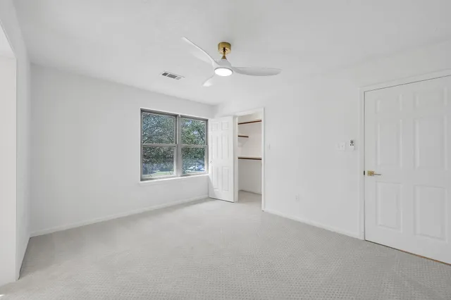 a view of a livingroom with a ceiling fan and window