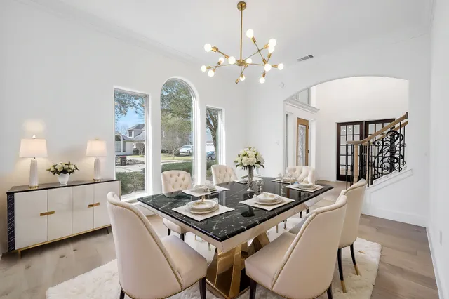 a kitchen with a table chairs and white cabinets