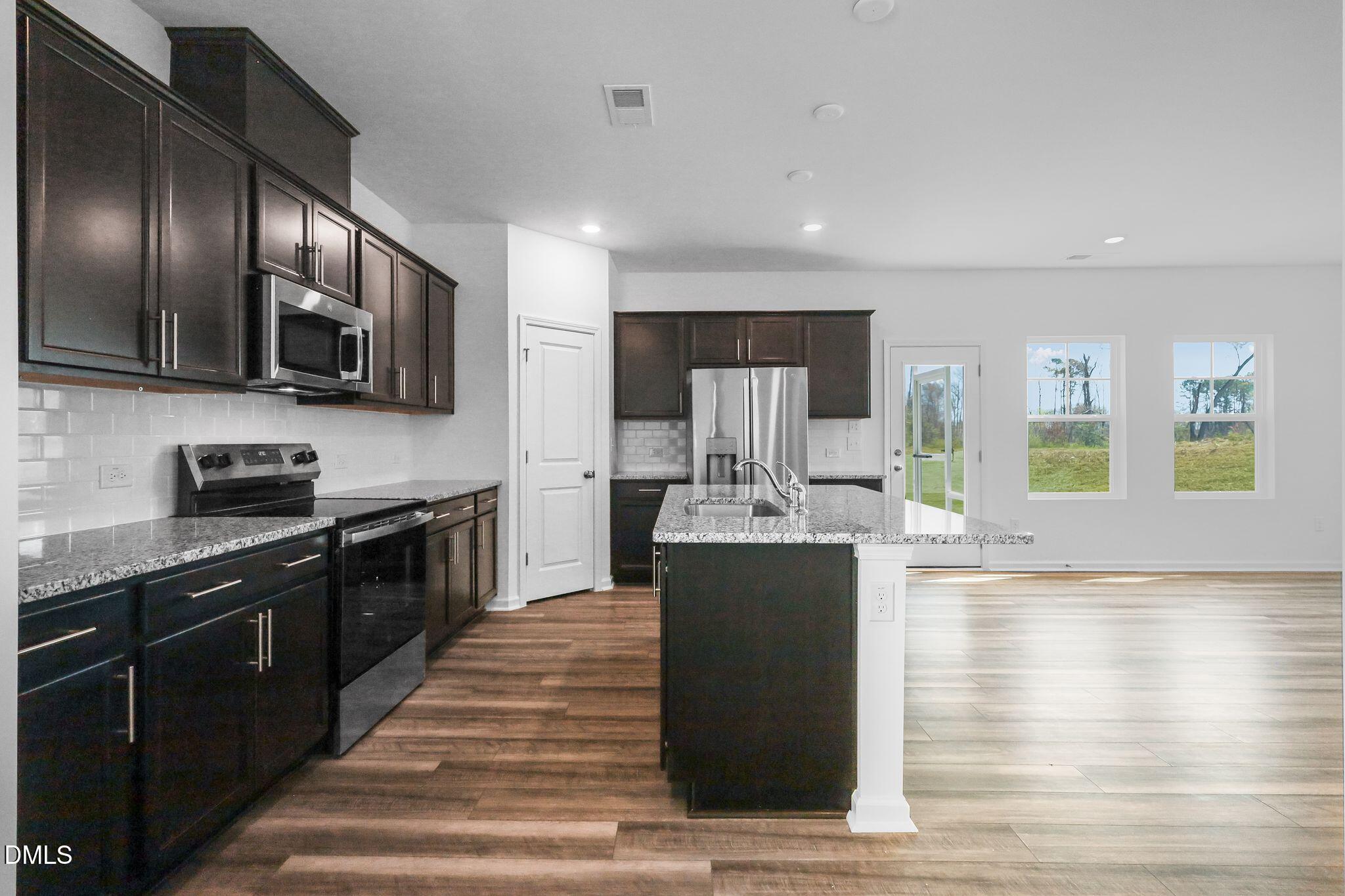 5818 Millstone Way Sims, NC 27880 - Photo 8 of 24 a kitchen with stainless steel appliances kitchen island granite countertop a stove and a refrigerator