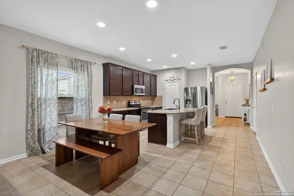 a kitchen with stainless steel appliances granite countertop a stove top oven a sink dishwasher and a refrigerator