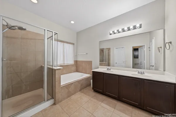 a bathroom with a tub a sink and mirrors