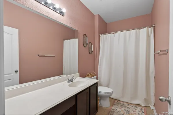 a bathroom with a sink a toilet and shower curtain