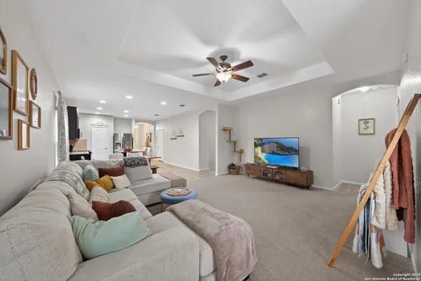 a living room with furniture and a ceiling fan