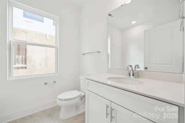 a bathroom with a toilet a sink a mirror and a window