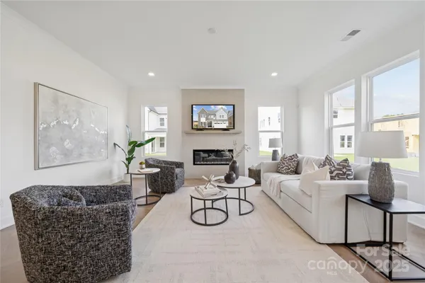 a living room with furniture a rug and white walls