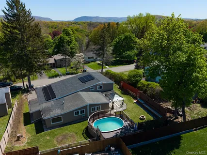 an aerial view of a house with backyard swimming pool and outdoor seating
