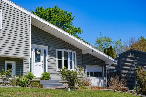 a front view of a house with a yard and potted plants