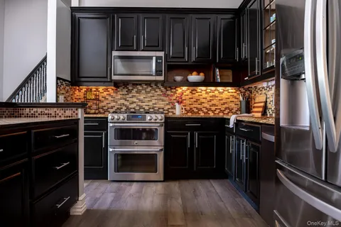 a kitchen with stainless steel appliances wooden cabinets and a stove top oven