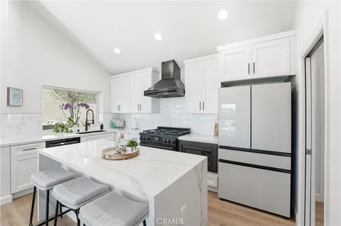 a kitchen with stainless steel appliances granite countertop a stove a table and chairs in it
