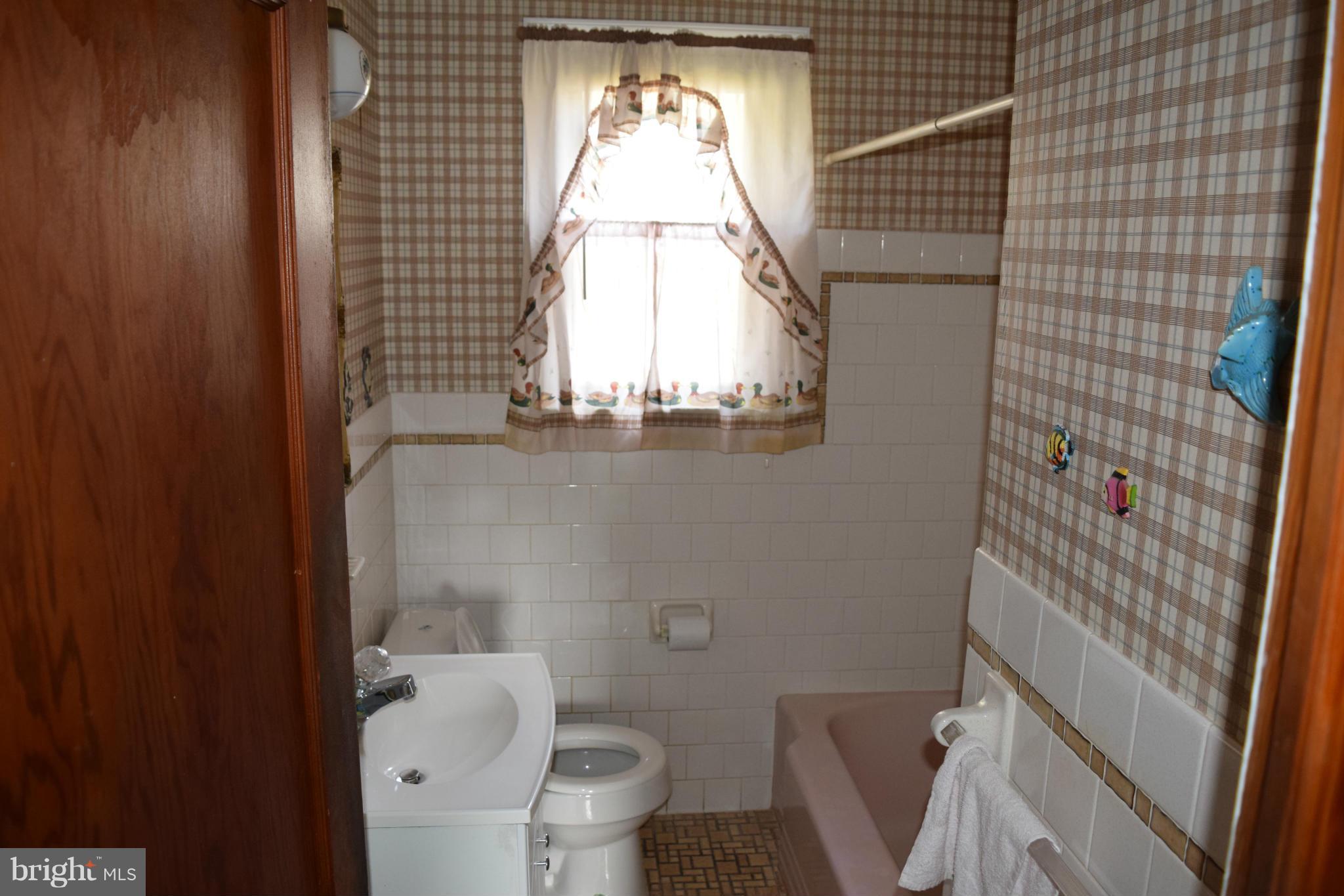 314 Worton Road Baltimore, MD 21221 - Photo 10 of 30 a bathroom with a toilet a sink and a window