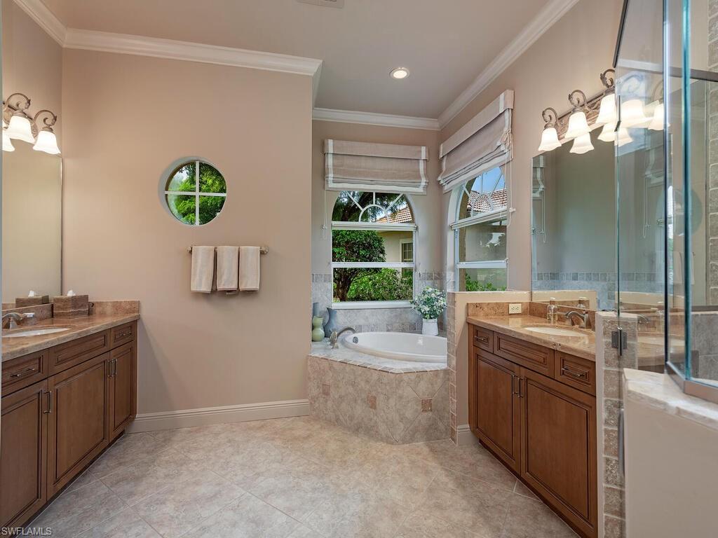 1749 Supreme Court Naples, FL 34110 - Photo 8 of 18 a bathroom with a granite countertop sink a large mirror and a bathtub with shower