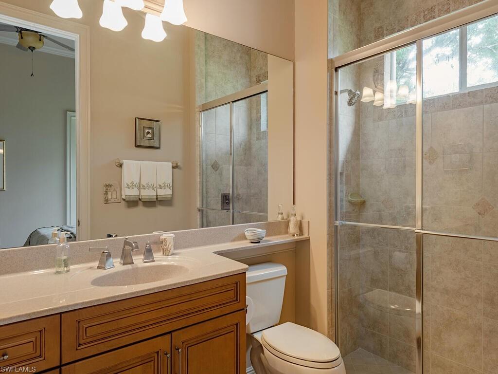 1749 Supreme Court Naples, FL 34110 - Photo 10 of 18 a bathroom with a sink toilet a mirror and shower