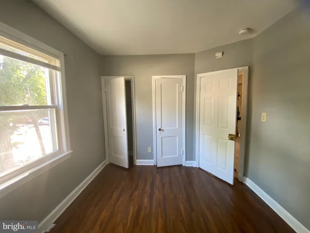 a view of hallway with bathroom and wooden floor