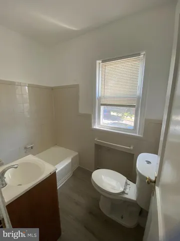 a bathroom with a sink a toilet and a window