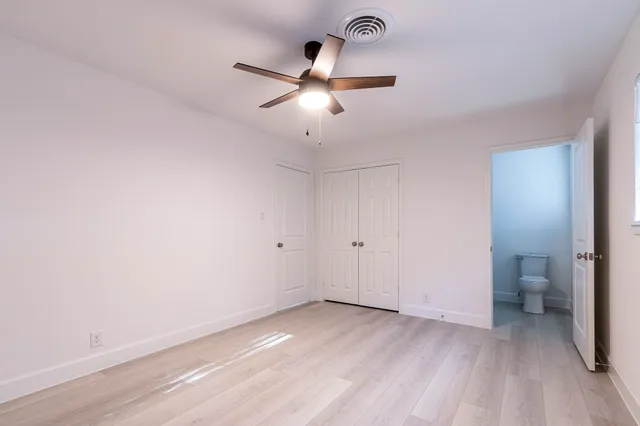 a view of a room with a ceiling fan and wooden floor