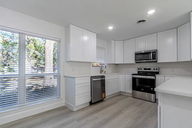 a kitchen with granite countertop a stove a sink and a microwave