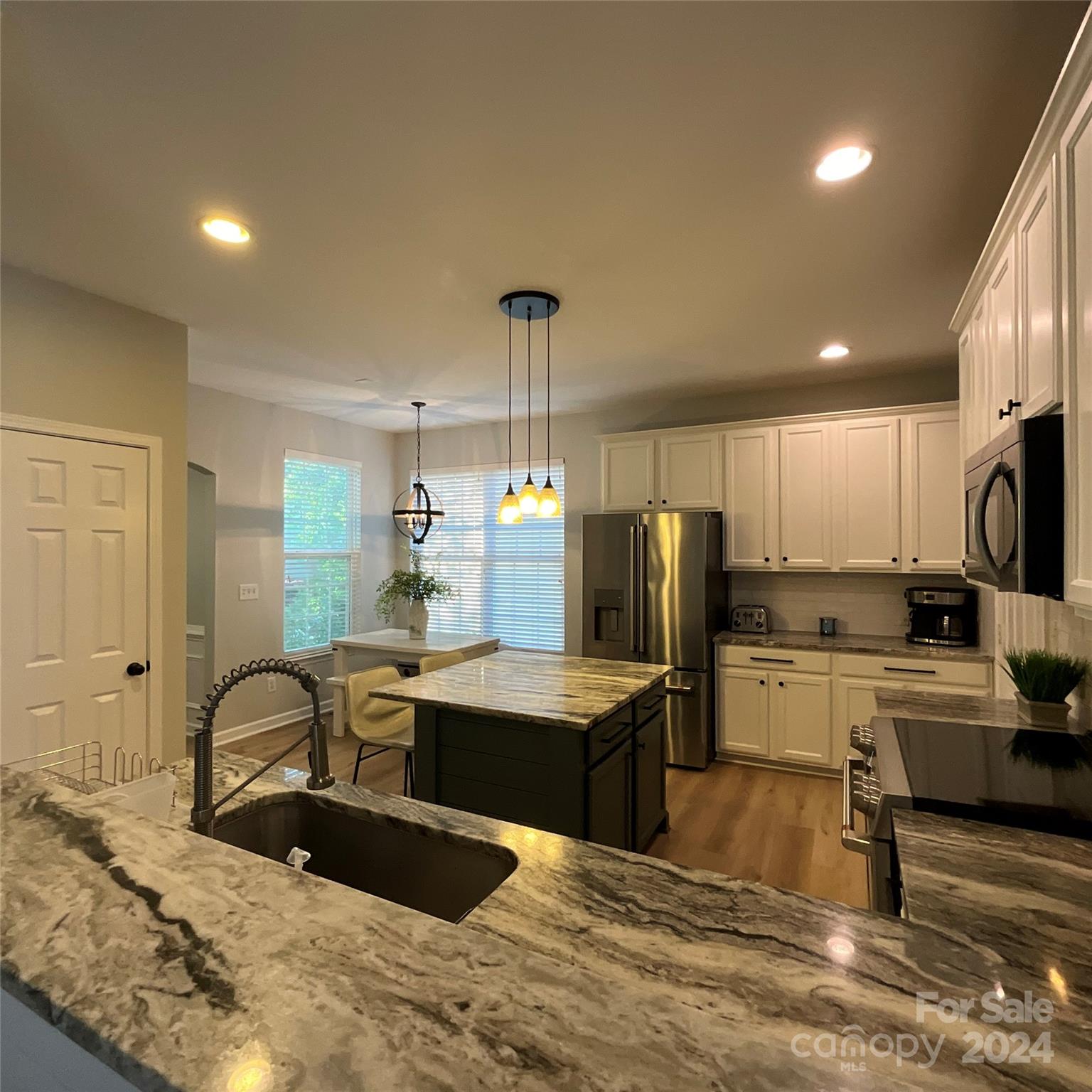 8126 Evanston Falls Road Huntersville, NC 28078 - Photo 14 of 42 a kitchen with stainless steel appliances granite countertop a sink refrigerator and cabinets