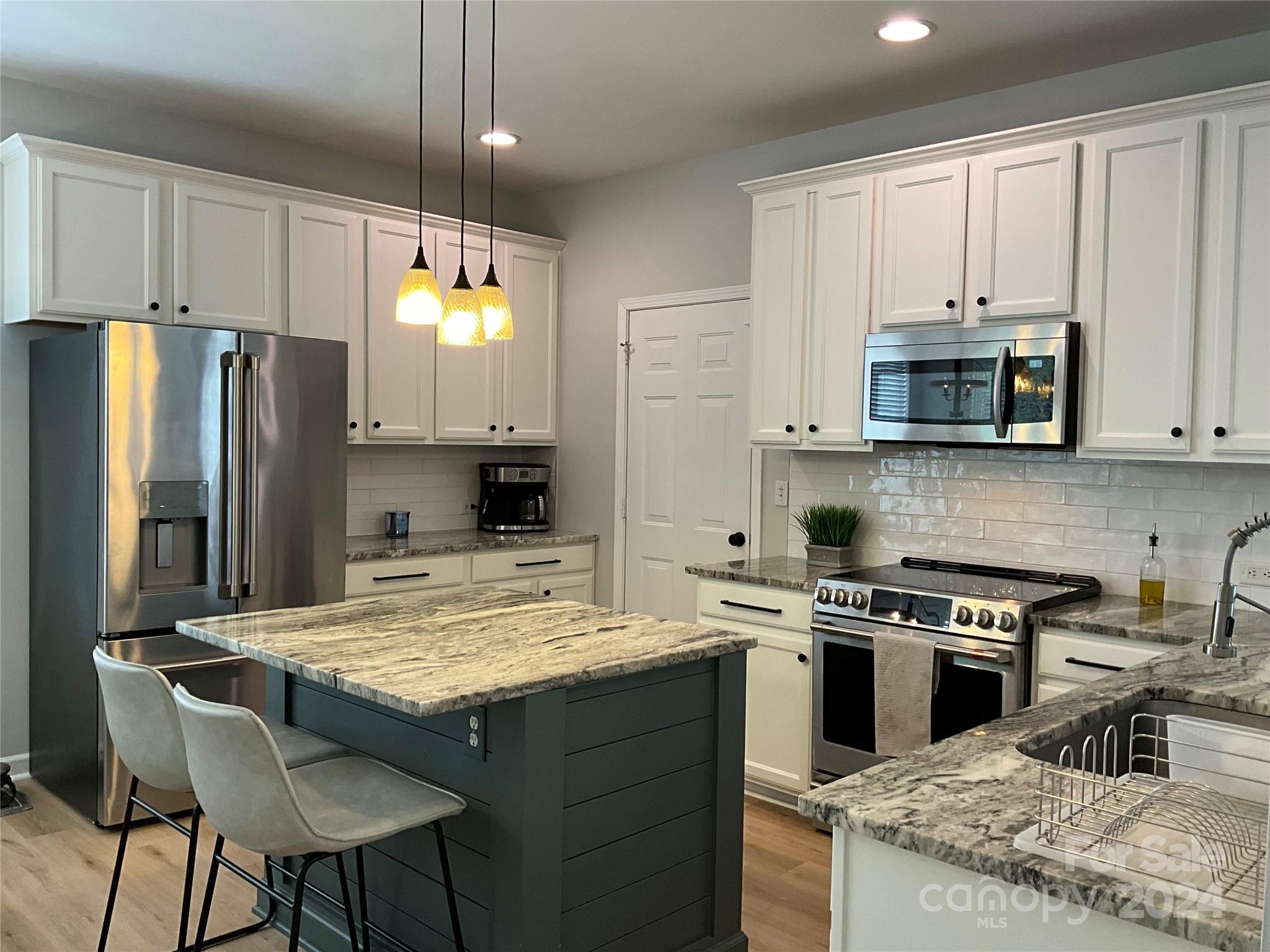 8126 Evanston Falls Road Huntersville, NC 28078 - Photo 16 of 42 a kitchen with a stove a refrigerator and a microwave