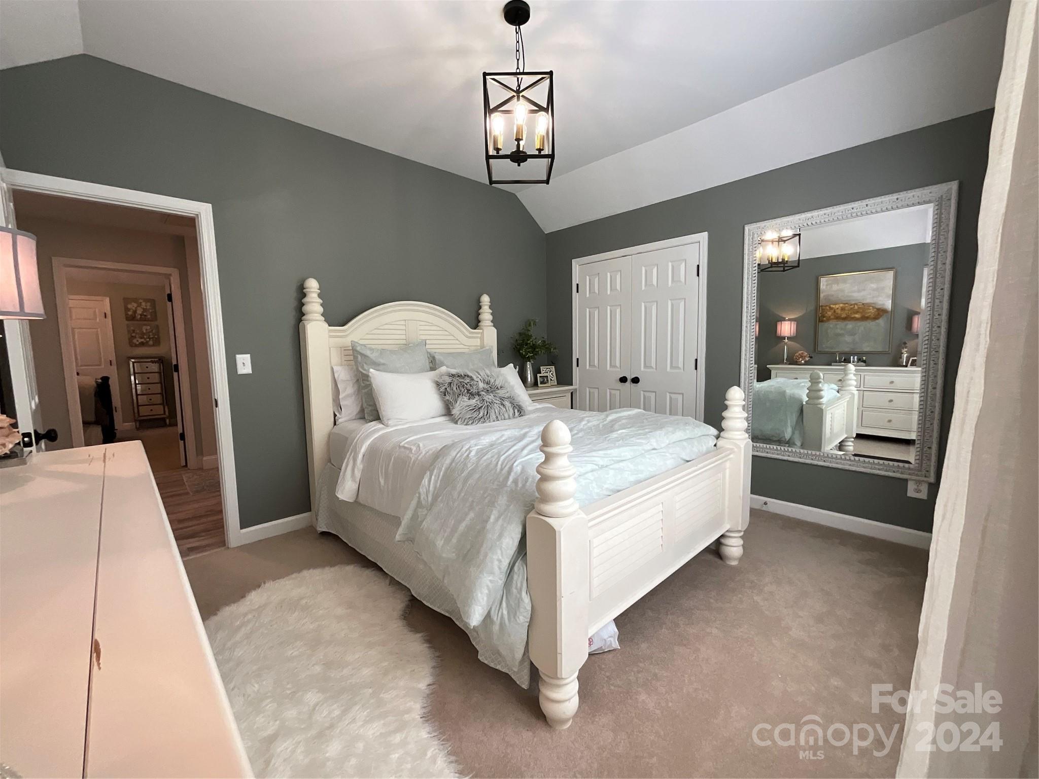 8126 Evanston Falls Road Huntersville, NC 28078 - Photo 28 of 42 a bedroom with a large bed and a chandelier