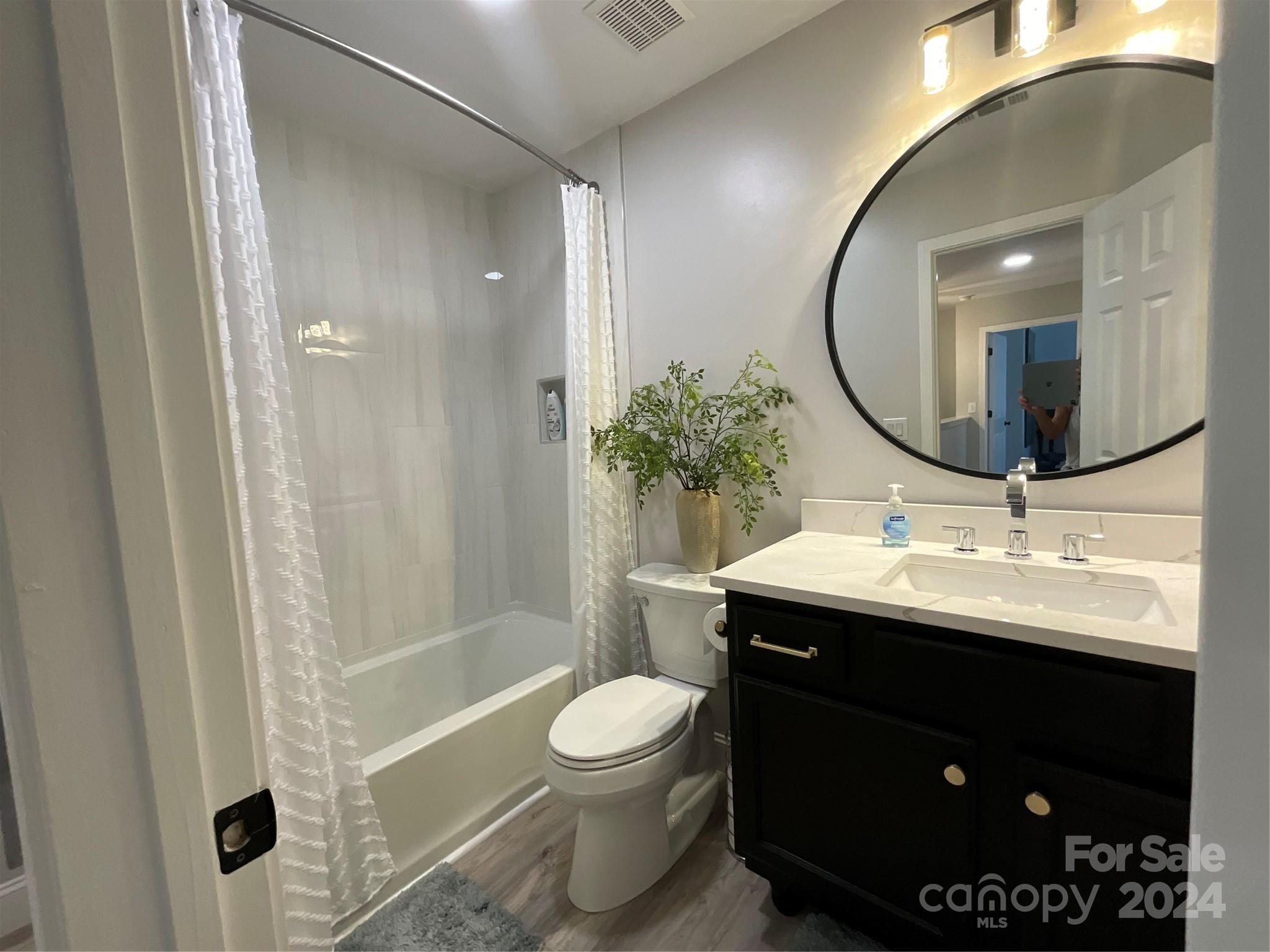 8126 Evanston Falls Road Huntersville, NC 28078 - Photo 32 of 42 a bathroom with a sink toilet a mirror and shower