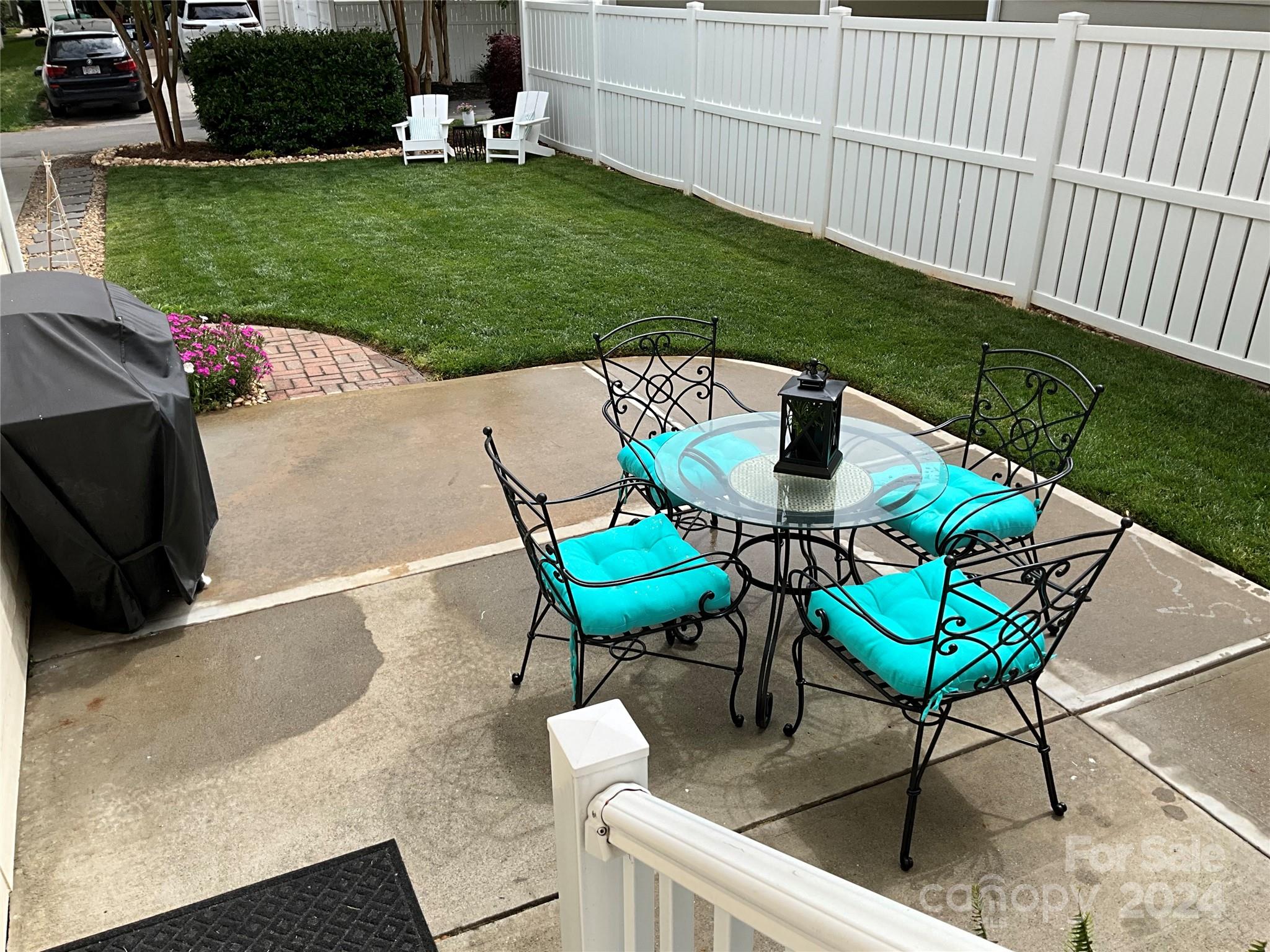 8126 Evanston Falls Road Huntersville, NC 28078 - Photo 35 of 42 a view of a backyard with table and chairs potted plants and wooden fence