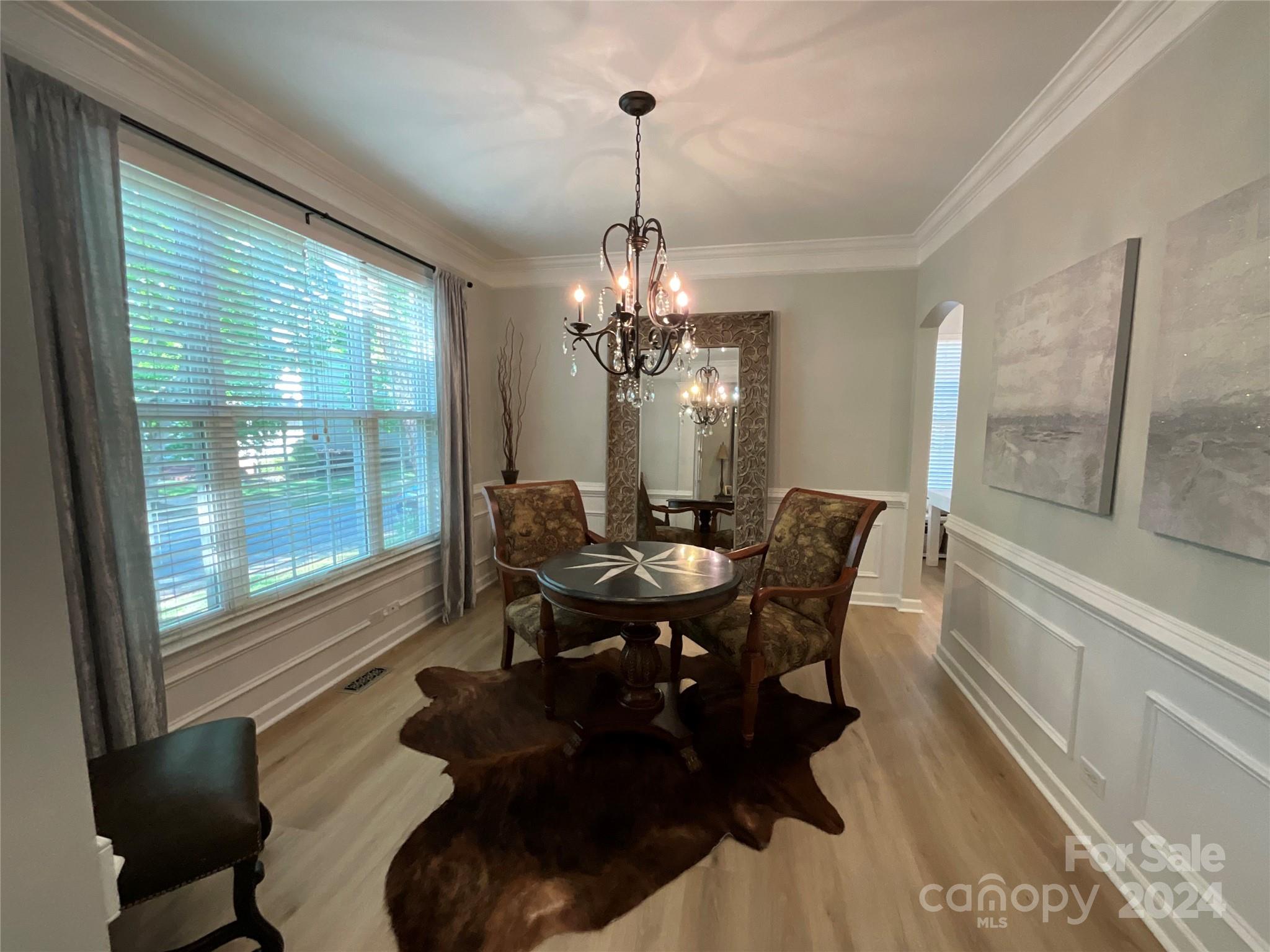 8126 Evanston Falls Road Huntersville, NC 28078 - Photo 7 of 42 a dining room with furniture a chandelier and wooden floor