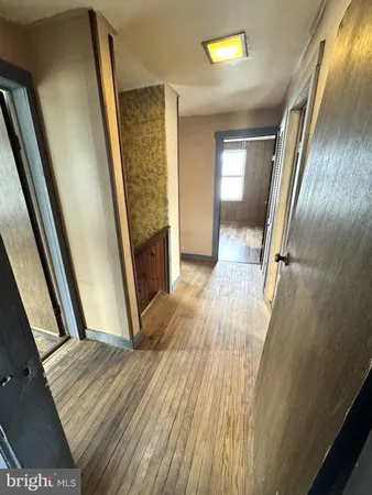 a view of a hallway with wooden floor and stairs