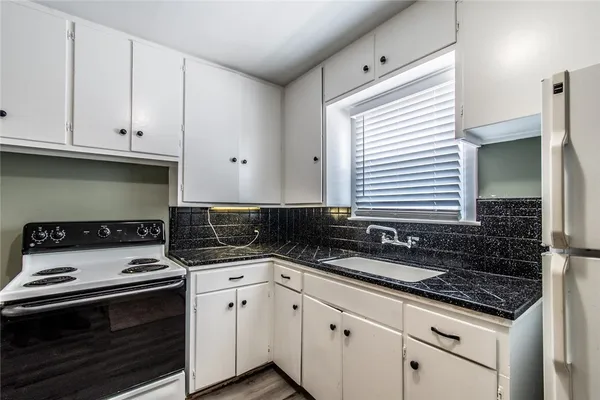 a kitchen with granite countertop a stove and a sink