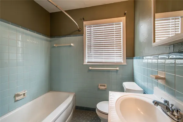 a bathroom with a toilet a sink and bathtub
