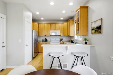 a kitchen with a table chairs refrigerator and microwave