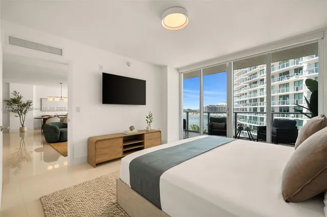 a large bedroom with a bed and glass window