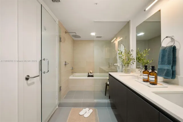 a bathroom with a double vanity sink mirror double and shower