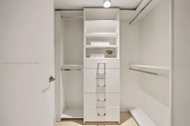 a view of walk in closet with empty racks