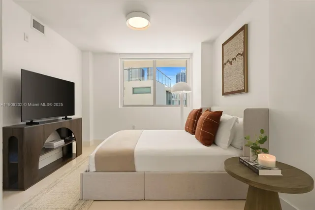 a bedroom with a bed and flat screen tv