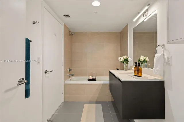 a bathroom with a sink vanity and tub