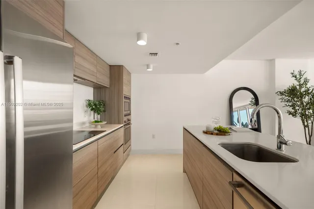 a kitchen with stainless steel appliances granite countertop a sink a refrigerator and a stove