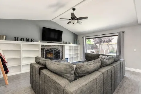 a living room with furniture a flat screen tv and a fireplace