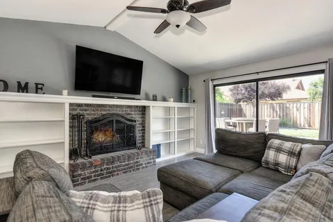 a living room with furniture a flat screen tv and a fireplace