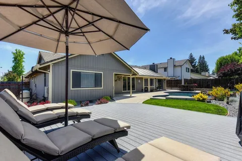 a view of a house with backyard and sitting area