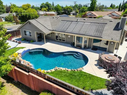 an aerial view of a house with swimming pool patio and lake view