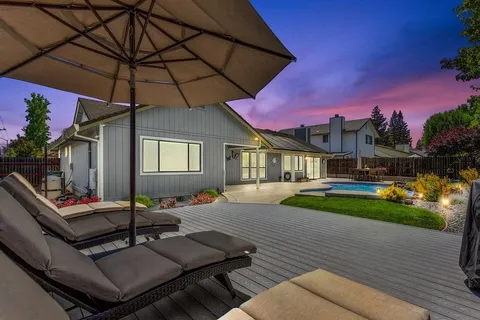 a patio with a table and chairs under an umbrella