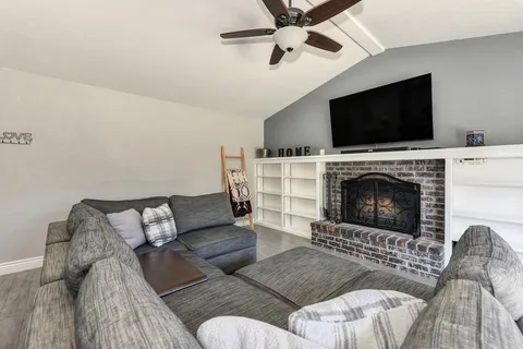 a living room with furniture a flat screen tv and a fireplace