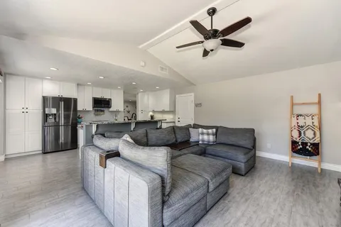 a living room with furniture and kitchen view