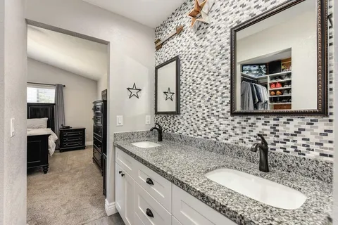 a bathroom with a granite countertop sink and a mirror
