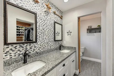 a bathroom with a granite countertop sink and a mirror